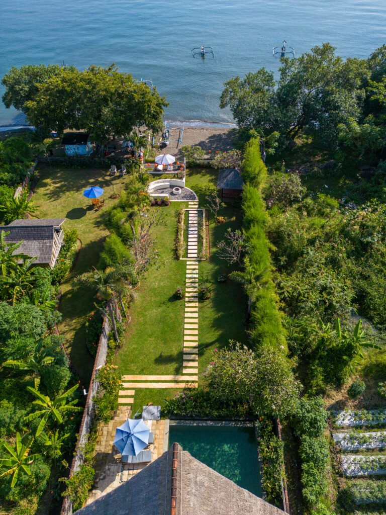 Aerial view of a beachfront villa on the calm north coast of Bali.