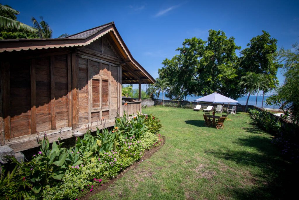 The Joglo's beachfront garden in Temukus, with sun loungers and parasol facing the Bali Sea