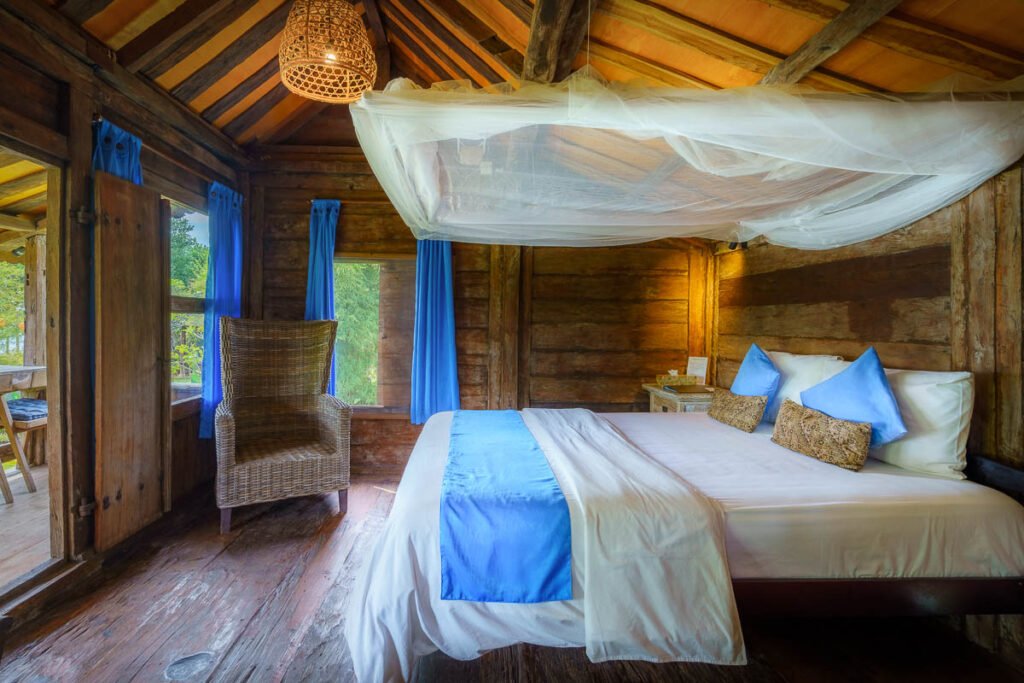 Bedroom inside the Joglo, a four-poster bed with mosquito net under original teak roof beams