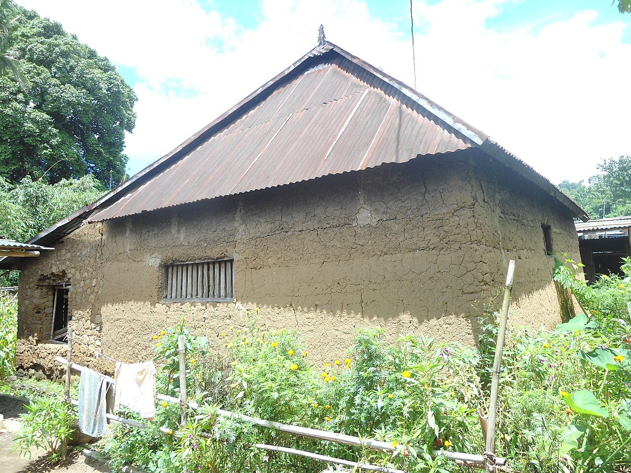 Traditional Bali Aga house with earthen walls and a low roof in Sidetapa village, North Bali